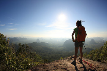 successful woman backpacker hiking on mountain peak