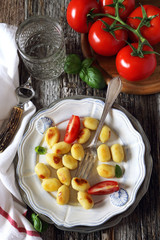 Fried potato gnocchi with cheese and tomatoes
