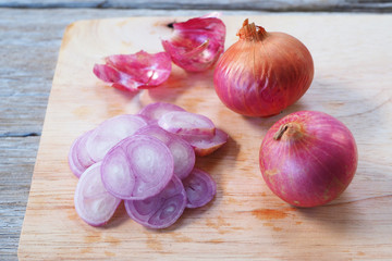 Sliced red onion on a wooden cutting board.
