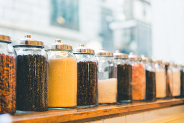Jars of coffee beans, instant coffee, sugar, and ingredients in vintage tone, depth of field effect, with copy space