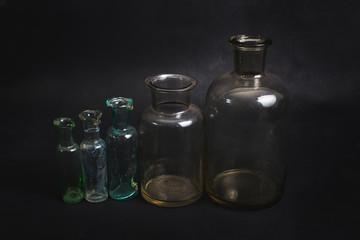 Obraz na płótnie Canvas Empty bottles are shown on a dark background