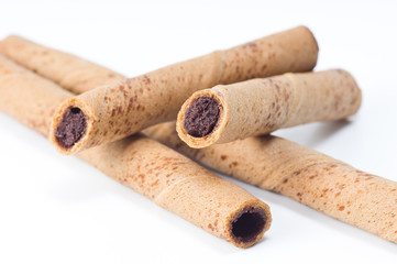 rolled wafer filled with chocolate fudge on white background