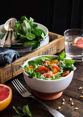 Quinoa salad with tomatoes, avocado, grapefruit, pine nuts and mint served in a bowl