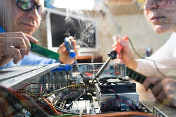 Two Computer Technicians repairing Hardware throw the window image