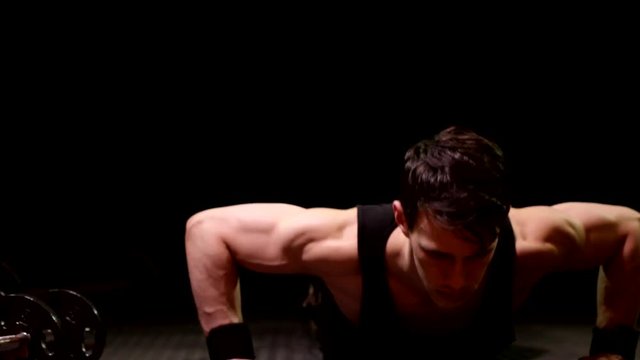 Push up exercise. Studio shot over black.
