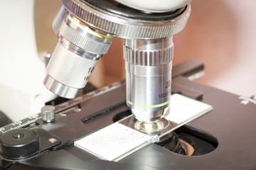 Laboratory microscope. Close-up view of objectives lenses and stage with microslide