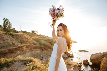 Young beautiful woman in wedding dress on beach