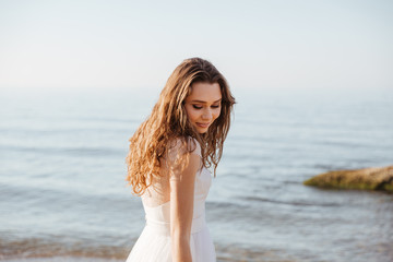 Fototapeta na wymiar Young beautiful woman in wedding dress on beach