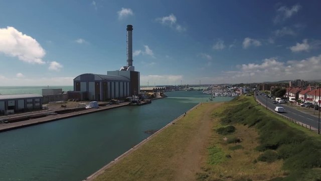 Aerial view of a power station between a river and the sea