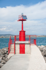 Fototapeta na wymiar Red marine warning beacon on harbor dock