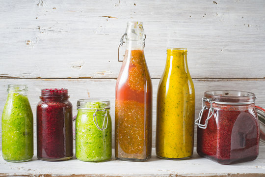 Bottles and jar with different smoothie on the  wooden board horizontal
