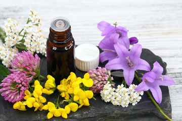 Fototapeta na wymiar Essential oil & meadow flowers