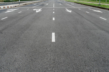 Asphalt road with arrow sign and white dot line