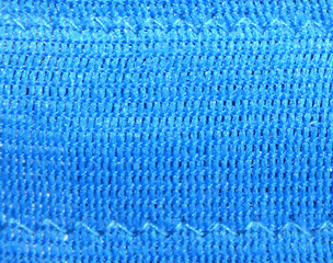 Bright blue fabric texture with threads. Jeans background.