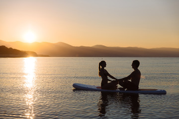 Naklejka na ściany i meble Silhouette of perfect couple engage standup paddle boarding