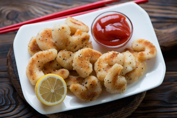Plate with king shrimps fried in panko breadcrumbs, close-up