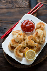 Fried panko breaded shrimps served with sauce and lemon, closeup