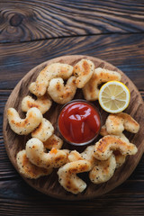 Fried breaded king shrimps, rustic wooden setting, above view