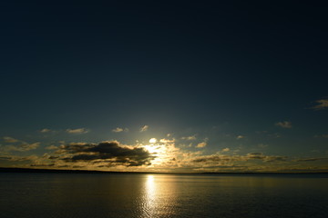 Fototapeta na wymiar Summer evening on the lake at sunset under the blue sky