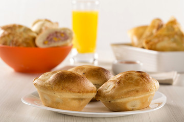 Empada Brazilian snack. pie with chicken on white plate on woode