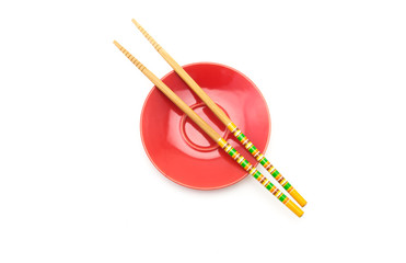 Plate with chopsticks on white background