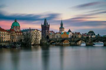 Obraz na płótnie Canvas Amazing towers of Charles bridge and old town district with reflection at Vltava river during cloudy sunset, Prague, Czech republic