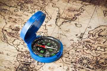 blue plastic compass on vintage map