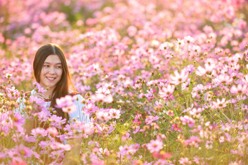 Naklejka premium Woman and Cosmos flowers blooming in the garden