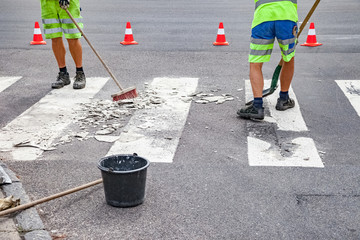 Straßenarbeiter erneuern Zebrastreifen
