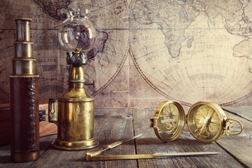 Ship lamp, compass, divider and spyglass on the wood table. Travel and nautical theme grunge...