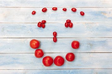 Naklejka na ściany i meble Red organic tomatoes on a blue wooden board, top view