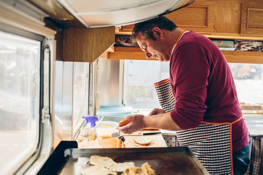 Adult man is cooking hamburger