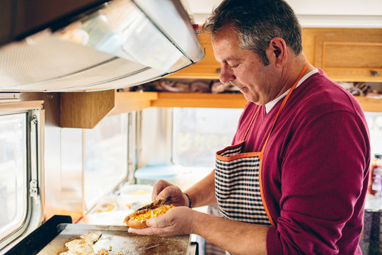 Adult man is cooking hamburger