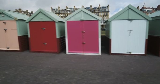 Dolly panning view of colorful beach huts in Brighton and Hove