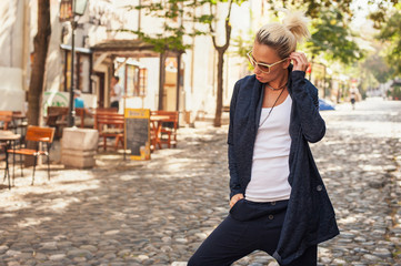 Attractive blonde woman posing on the street. Fashion lifestyle