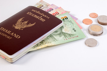 Thai Passport with Thai money banknote and Thai coin isolated on white. The passport of Thai citizen on Thai banknote.