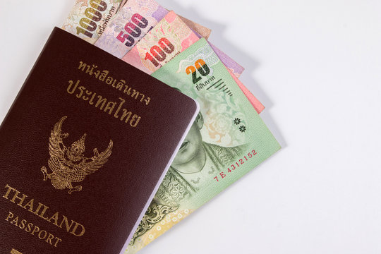 Thai Passport with thai money banknote isolated on white. The passport of Thai citizen on Thai banknote.
