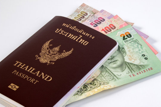 Thai Passport with thai money banknote isolated on white. The passport of Thai citizen on Thai banknote.