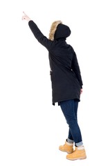 Naklejka premium Back view of pointing young women in parka. Young girl gesture. Rear view people collection. backside view of person. Isolated over white background. 
