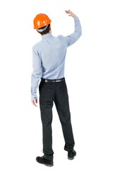 Backview of an engineer in construction helmet stands. Standing young guy. Rear view people collection.  backside view of person.  Isolated over white background. Engineer beckons to her employee.