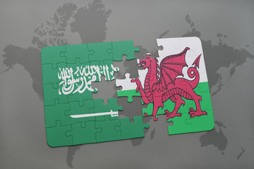 puzzle with the national flag of saudi arabia and wales on a world map background.
