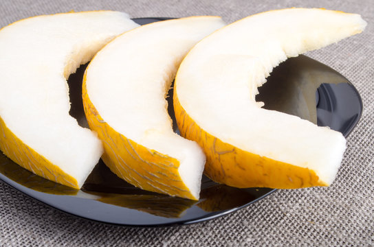 Healthy yellow melon on a black plate