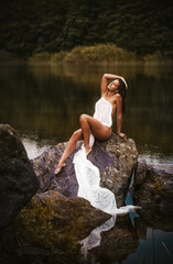 Attractive woman in white cloth on the rock