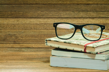 Books and eyeglasses on wooden.