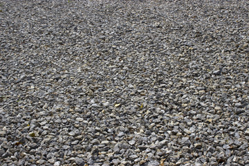 Rough uneven gray stone background old curve sprinkled gravel