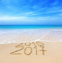 2016 and 2017 on a beach sand