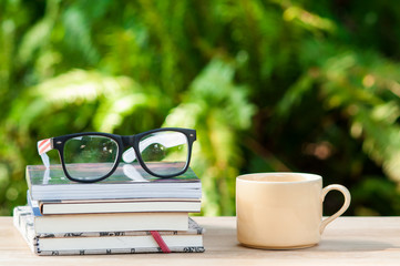 Books and eyeglasses on wooden.