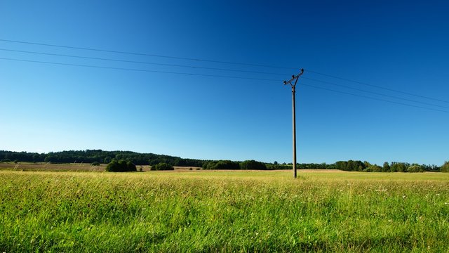 Summer meadow with single electric pillar