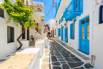 Narrow street with white houses in beautiful Mykonos town, Cyclades islands, Greece