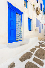 Fototapeta premium Blue door and windows of typical house on street of beautiful Mykonos town, Cyclades islands, Greece